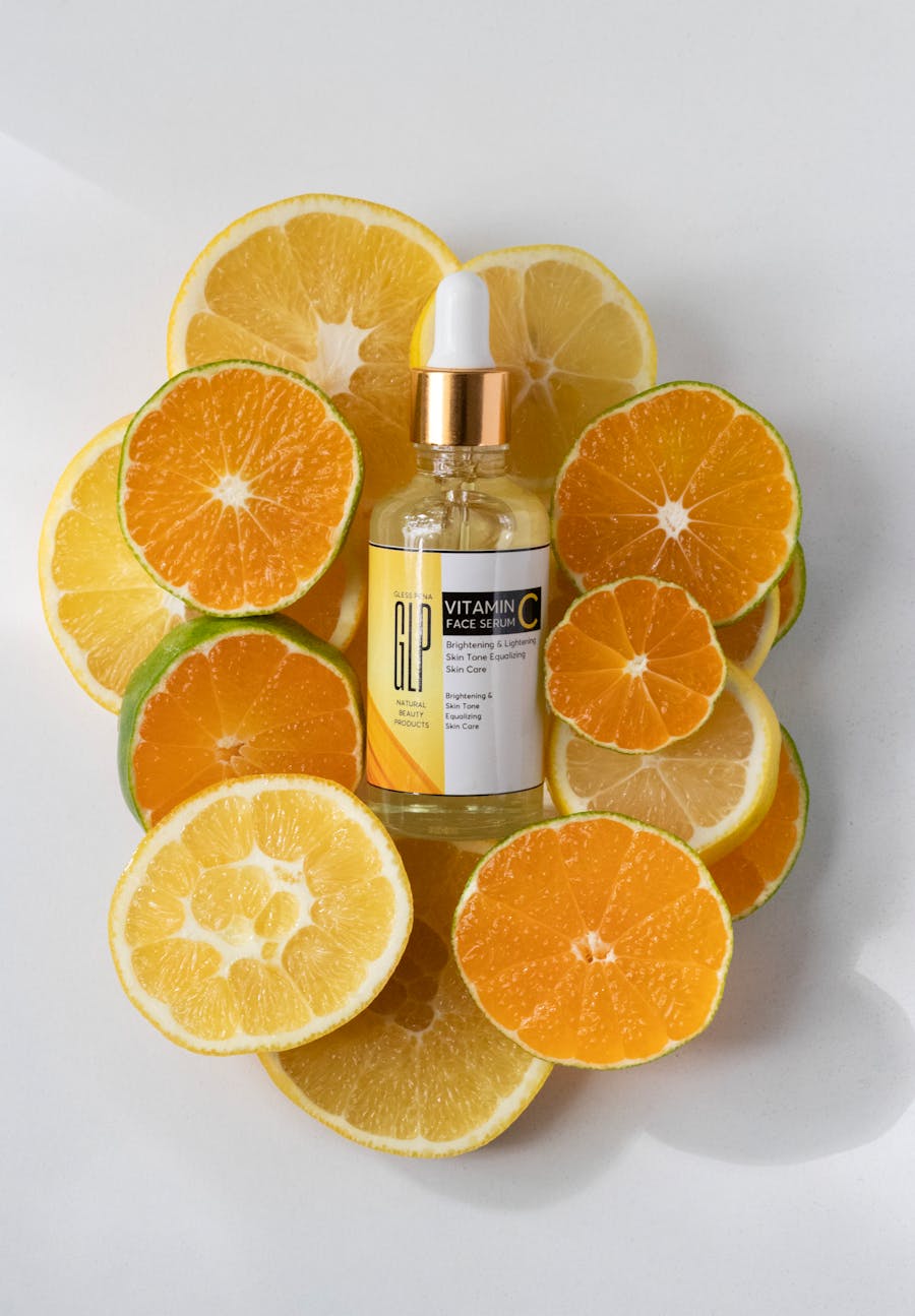 Vitamin C face serum bottle displayed with fresh citrus slices